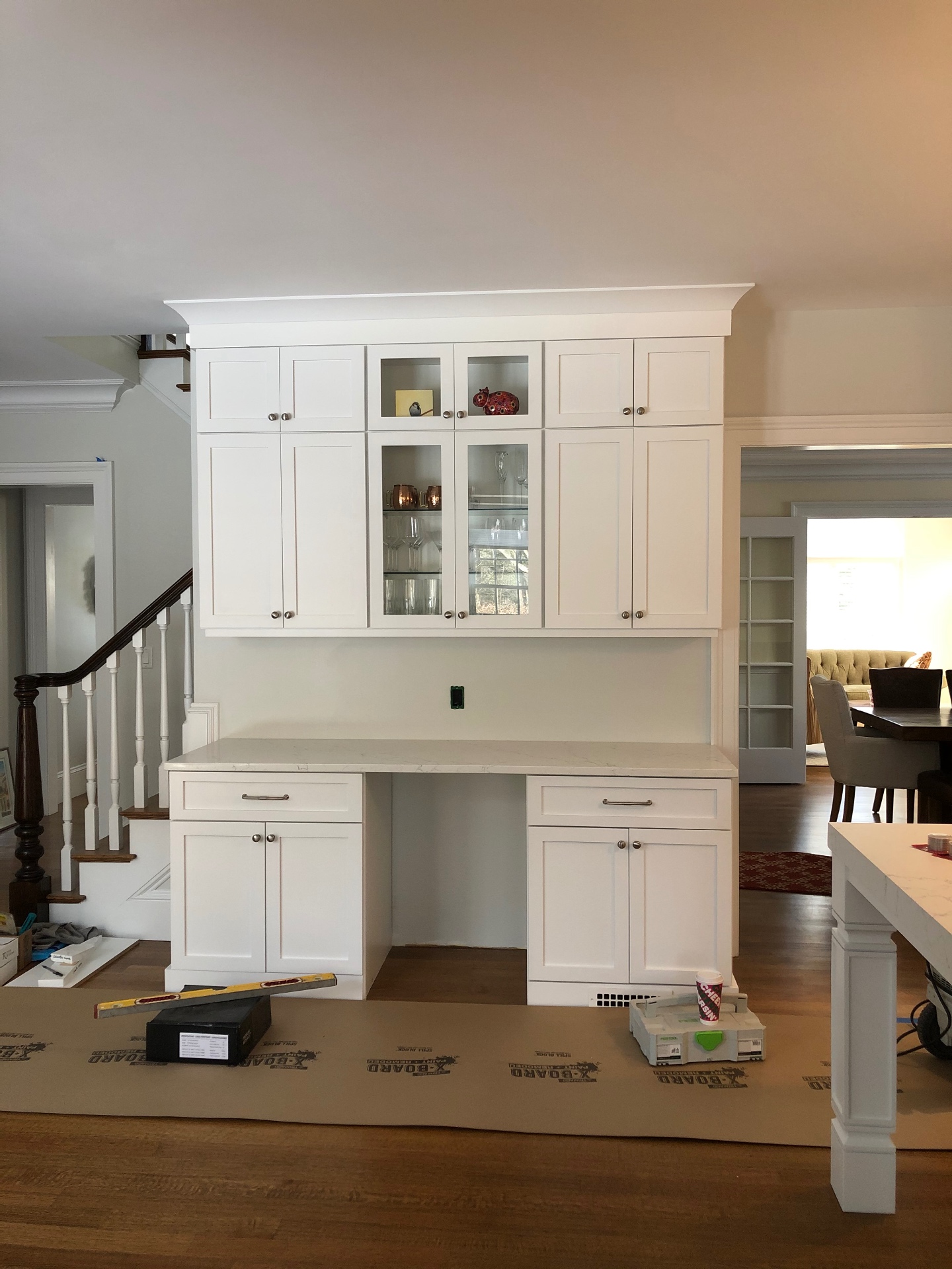 White kitchen with custom built-in desk and glass cabinets